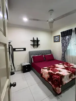 a bedroom with a bed with a red bedspread at Gombak Fatin Homestay in Kuala Lumpur