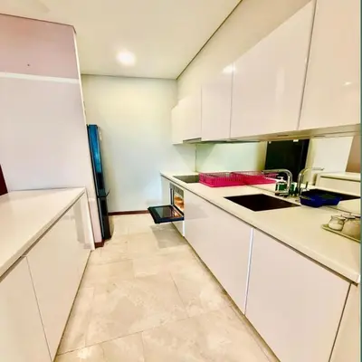 a kitchen with white cabinets and a tile floor at Sky suites klcc by sky view in Kuala Lumpur