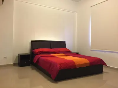 a bedroom with a bed with a red and orange blanket at The Forum Kuala Lumpur in Kuala Lumpur