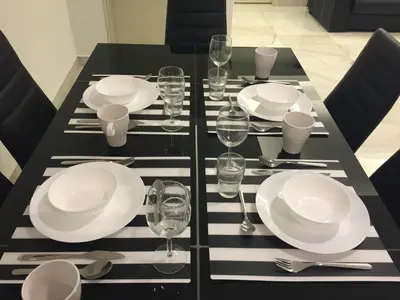 a black table with white plates and wine glasses at The Forum Kuala Lumpur in Kuala Lumpur