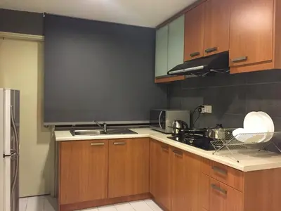 a kitchen with wooden cabinets and a black wall at The Forum Kuala Lumpur in Kuala Lumpur