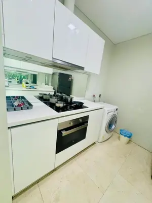 a white kitchen with a stove and a washing machine at Vortex suites Near Klcc By I&J in Kuala Lumpur