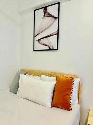 a bed with four pillows and a picture on the wall at The Agile Residence By Signature in Kuala Lumpur