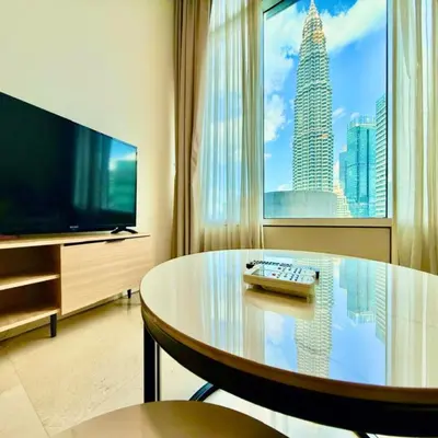 a living room with a table and a large window at sky suites by klcc in Kuala Lumpur