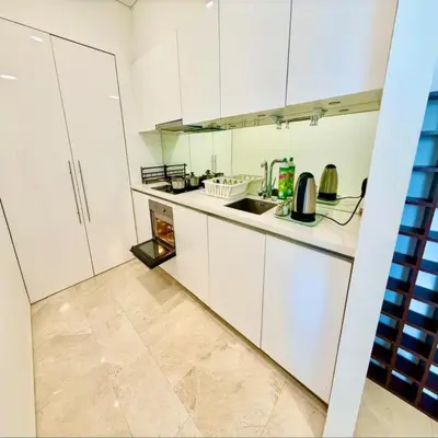 a kitchen with white cabinets and a sink at sky suites by klcc in Kuala Lumpur