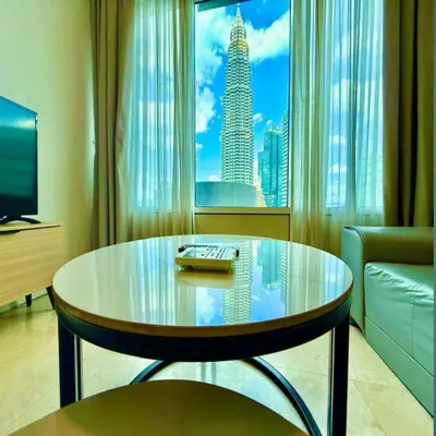 a living room with a glass table in front of a window at sky suites by klcc in Kuala Lumpur