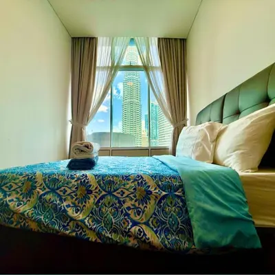 a bedroom with a bed with a view of a city at sky suites by klcc in Kuala Lumpur