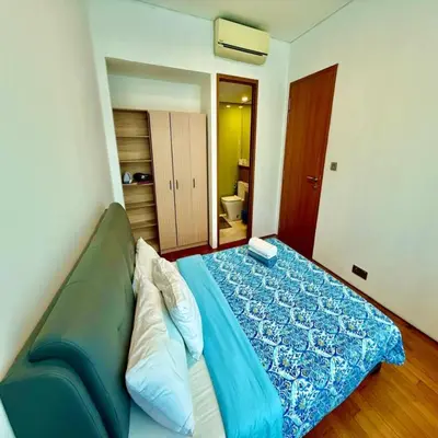 a bedroom with a bed with a blue blanket at sky suites by klcc in Kuala Lumpur