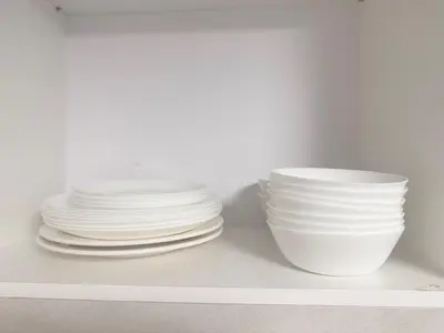 a stack of plates and bowls sitting on a shelf at 3 Bedrooms KLCC View PlazaRah,Kg Baru next to Rembayung in Kuala Lumpur