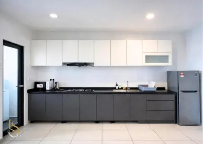 a kitchen with white cabinets and a stainless steel refrigerator at LUXORA SUITE's REIZZ RESIDENCE in Kuala Lumpur