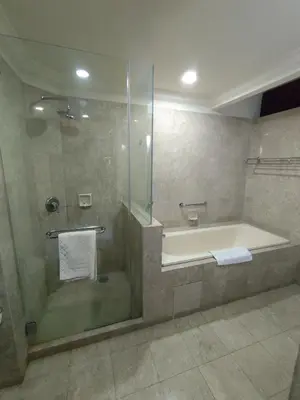 a bathroom with a tub and a shower with a glass door at Elements apartment service at Times Square in Kuala Lumpur