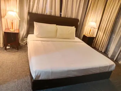 a bed in a hotel room with two lamps at Time Square Mountain View Apartment KL in Kuala Lumpur
