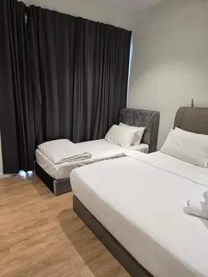 two beds in a room with black curtains at Kuala Lumpur Suites Quill in Kuala Lumpur