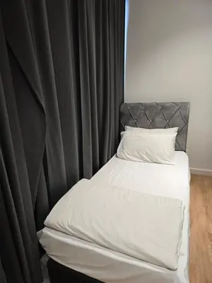 a bedroom with a bed with a black curtain at Kuala Lumpur Suites Quill in Kuala Lumpur