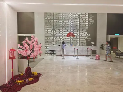 a person standing in a lobby with a table and flowers at Kuala Lumpur Suites Quill in Kuala Lumpur