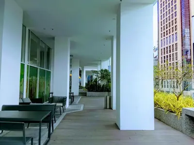 a hallway of a building with tables and chairs at Victoria Suites Quill Residence KLCC in Kuala Lumpur