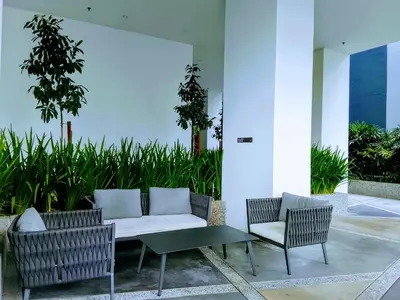 a patio with a white couch and two chairs at Victoria Suites Quill Residence KLCC in Kuala Lumpur