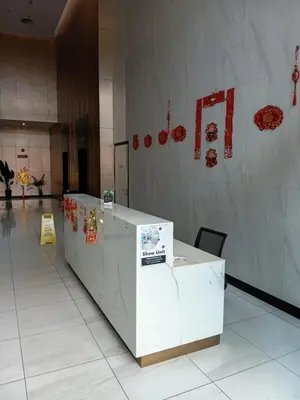 a row of white tables in a lobby with red signs at Infinitum suites KLCC Sky Pool by EXA in Kuala Lumpur