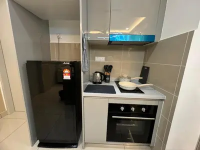 a small kitchen with a stove and a microwave at TRION KL, Jalan Chan Sow Lin, Kuala Lumpur in Kuala Lumpur