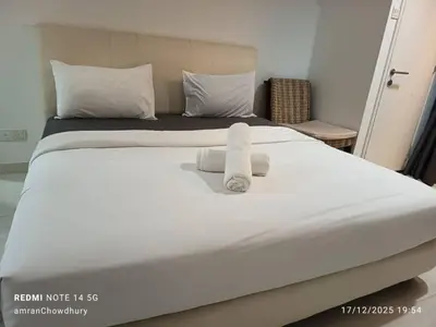 a large white bed with two towels on it at Binjai 8 KLCC BY Service Suites in Kuala Lumpur