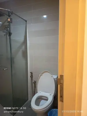 a bathroom with a toilet and a glass shower at Binjai 8 KLCC BY Service Suites in Kuala Lumpur