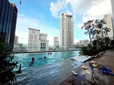a pool in a city with people swimming in it at Aurelia Suites Quill Residences in Kuala Lumpur