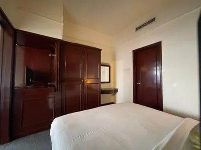 a bedroom with a bed and a wooden cabinet at Aurora Suites BUKIT At Times Square in Kuala Lumpur