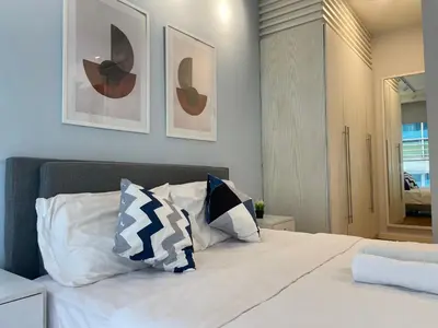 a bedroom with a white bed with two pillows at Fairlane Residence near Bukit Bintang KL in Kuala Lumpur