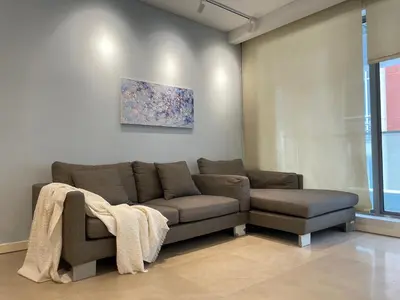 a living room with a couch and a painting at Fairlane Residence near Bukit Bintang KL in Kuala Lumpur