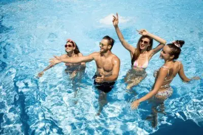 a group of people swimming in the water at TikiiBunk Packers in Kuala Lumpur