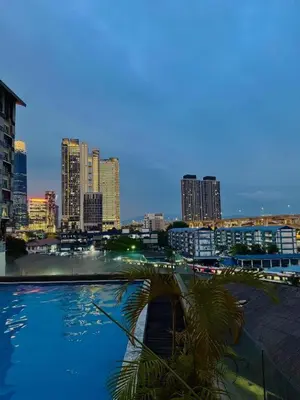 a view of a city at night with a palm tree at TikiiBunk Packers in Kuala Lumpur