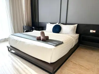a bedroom with a large bed with two slippers on it at Tropicana Residences CoolStay in Kuala Lumpur