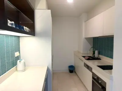 a kitchen with white cabinets and a counter top at Tropicana Residences CoolStay in Kuala Lumpur