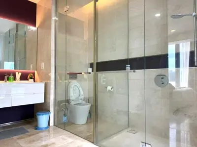 a bathroom with a toilet and a glass shower at Tropicana Residences CoolStay in Kuala Lumpur