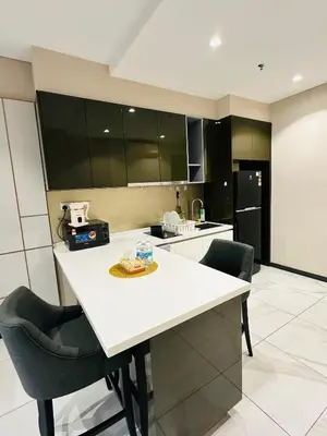 a kitchen with a white counter and some chairs at City towen klcc by TTR in Kuala Lumpur