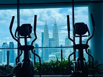 two exercise bikes in a gym with a view of the city at The luxe klcc by jaurami stay in Kuala Lumpur