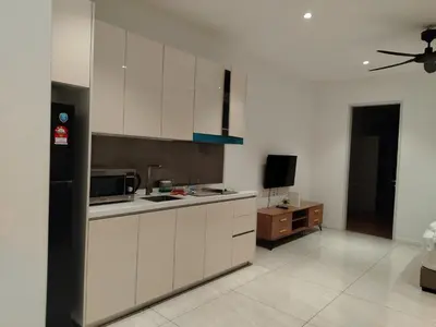 a kitchen with white cabinets and a tv in it at NEO Quill Residences klcc in Kuala Lumpur