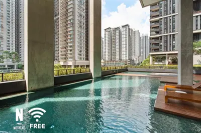 a swimming pool in the middle of a building with tall buildings at Arcoris SOHO Mont Kiara , Stylish 1 Bedroom Retreat in Kuala Lumpur