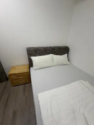a bedroom with a white bed and a wooden table at Bukit Bintang Suites KLCC by YBS in Kuala Lumpur