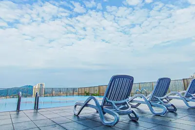 a row of chairs sitting on a balcony with a pool at Sky Pool at 3 Towers Ampang by HCK in Kuala Lumpur
