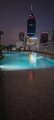 a large pool of blue water in a city at night at Queen Suites at Quill Residence KL in Kuala Lumpur