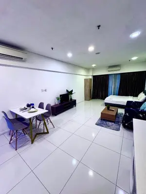 a living room with a bed and a table and chairs at Mercu Summer Suites KLCC by Jk Privy Homes - Entire Studio in Kuala Lumpur