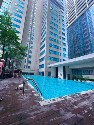 a swimming pool in front of a building with tall buildings at Mercu Summer Suites KLCC by Jk Privy Homes - Entire Studio in Kuala Lumpur