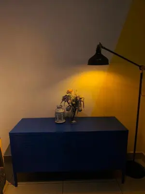 a blue dresser with a lamp and flowers on it at 10 Mins to KLCC Cozy Place to Stay in Kuala Lumpur