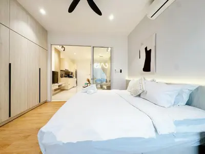 a bedroom with a large white bed and a kitchen at Veone Hotel Kuala Lumpur in Kuala Lumpur