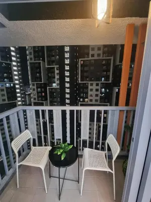 a balcony with chairs and a table and a view of a city at Awani3 Homestay, Setapak, KL in Kuala Lumpur