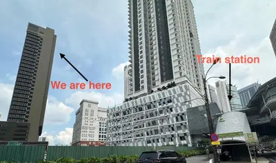 a large tall building with the words we are here at Staycay Majestic Residence KL in Kuala Lumpur