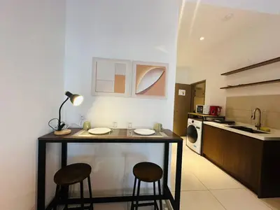 a kitchen with a table and two stools in a room at LA Majestic Suites at KlCC in Kuala Lumpur