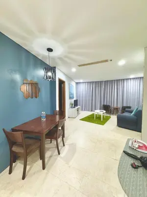 a living room with a table and a blue wall at Apartment Kuala Lumpur City 3 Minutes To KLCC in Kuala Lumpur