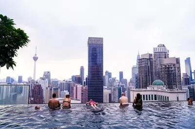 a group of people in a infinity pool with a city skyline at Axon Residences KLCC - CR Homestay in Kuala Lumpur